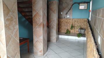 Une pièce avec un lit superposé en bois, un escalier et un mur en bambou.