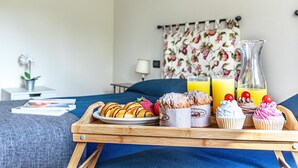 A breakfast tray with pastries, cupcakes, and juice on a bed. - Villa Elisa with pool (Padenghe sul Garda)