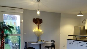 Cozinha moderna com área de refeições, uma janela ampla e uma escultura decorativa de cabeça de elefante.