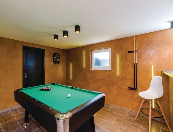 A pool table with balls, a dartboard, a window with a view, and a white chair. - Zaton Family Getaway Near Adriatic Sea (Dubrovnik)