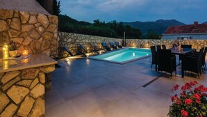 A stone wall, a pool, lounge chairs, and a table with chairs. - Zaton Family Getaway Near Adriatic Sea (Dubrovnik)