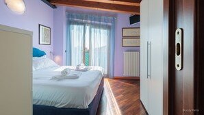 Una camera da letto con un letto, una finestra con tende, un termosifone e un soffitto in legno.