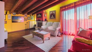 Un accogliente soggiorno con travi in legno, un caminetto, un divano e un tavolino.