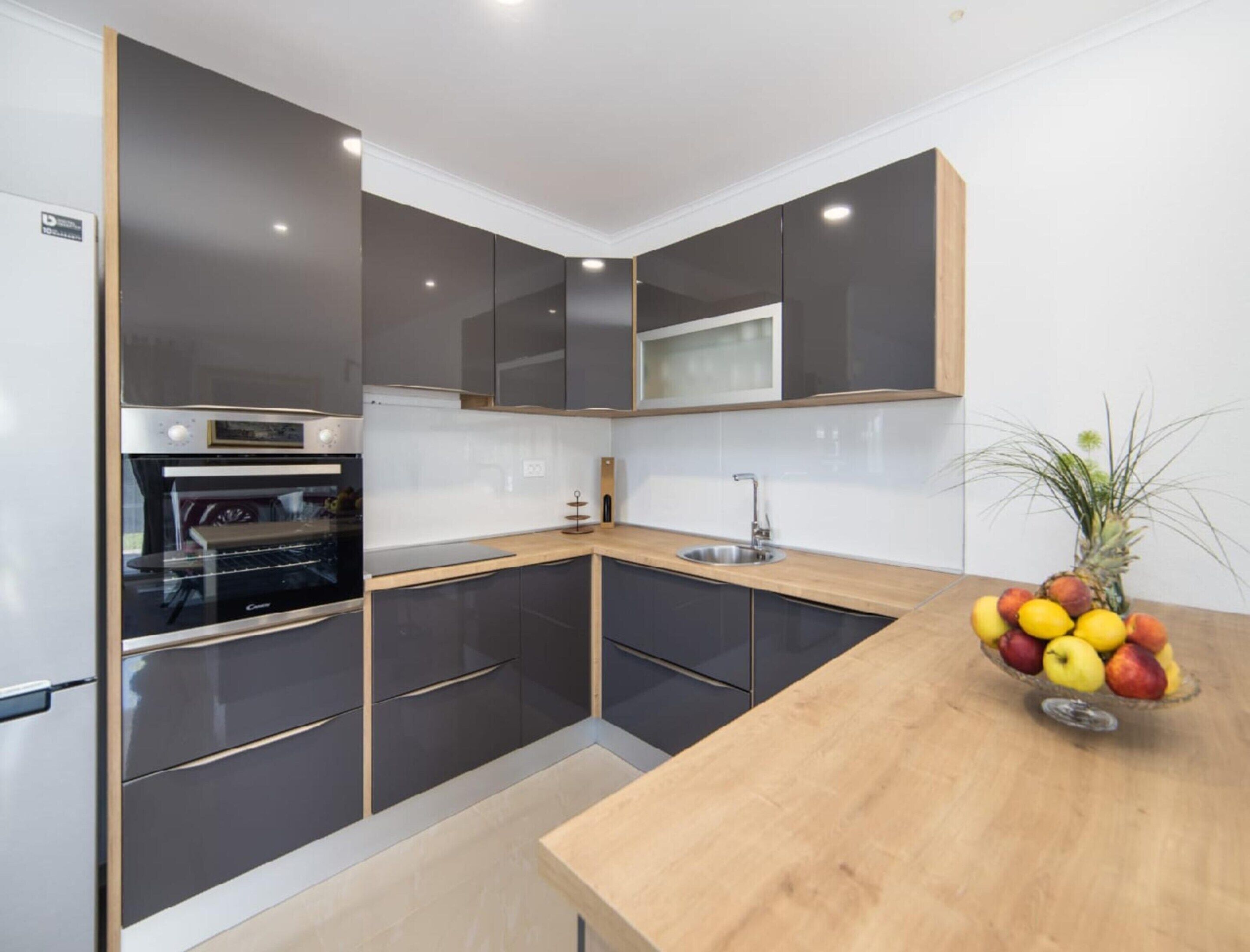 A modern kitchen with a built-in oven, a microwave, and a sink.