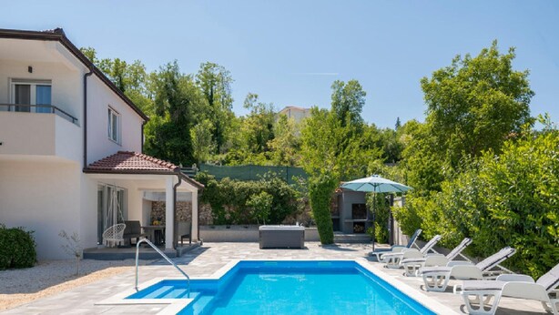 A swimming pool with lounge chairs, a covered seating area, and a building with a tiled roof. - Paradise Villa in the Countryside (Imotski)