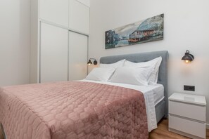 A bedroom with a bed, a painting, two wall-mounted lights, and a nightstand. - Stunning Dalmatian Villa With Pool for 10 (Split)