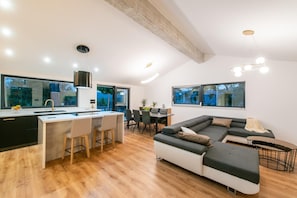 A modern interior with a kitchen island, dining area, and a large L-shaped sofa. - Stunning Dalmatian Villa With Pool for 10 (Split)