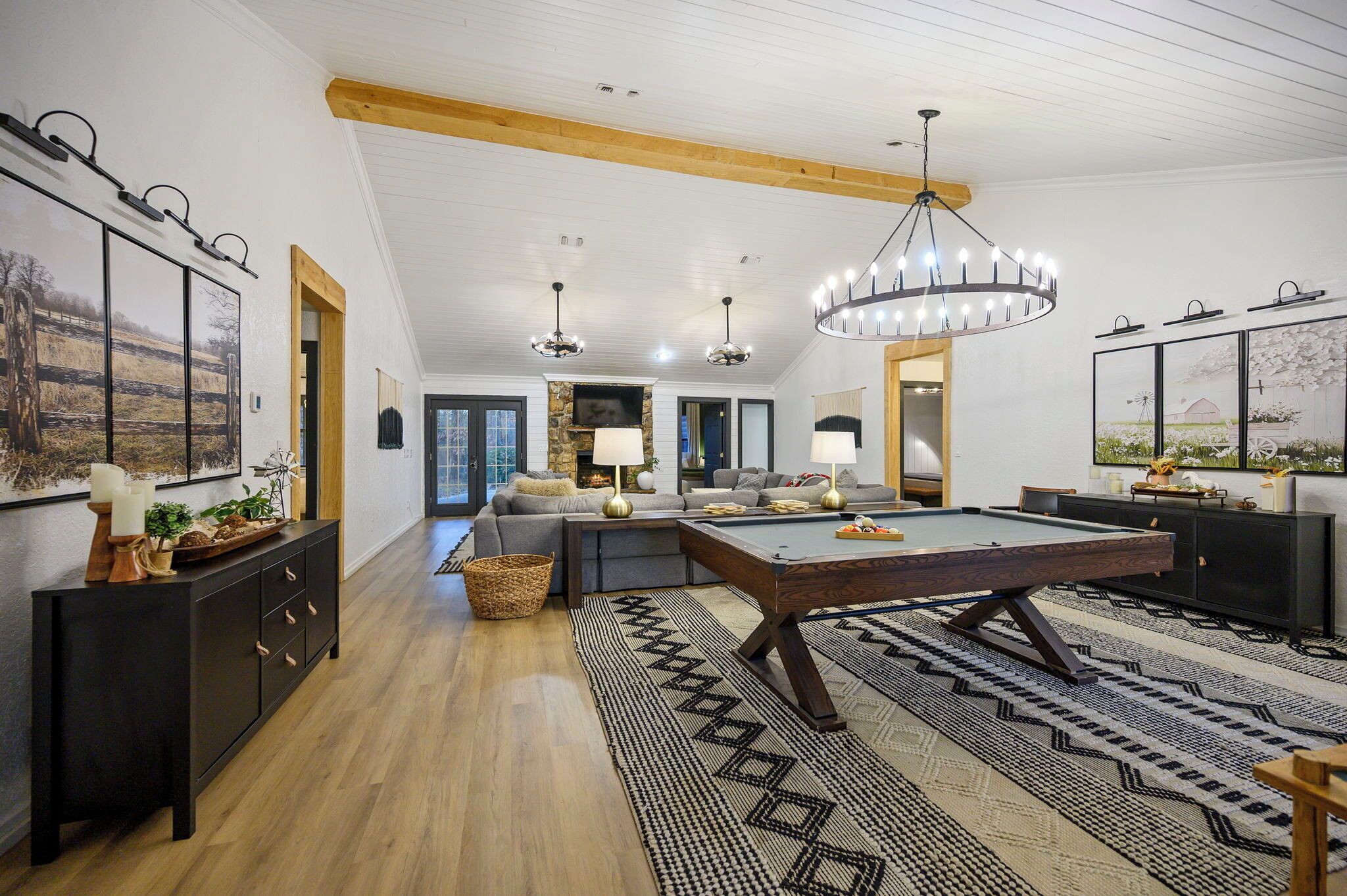 Un salon spacieux avec une table de billard, des meubles en bois foncé et un grand tapis.