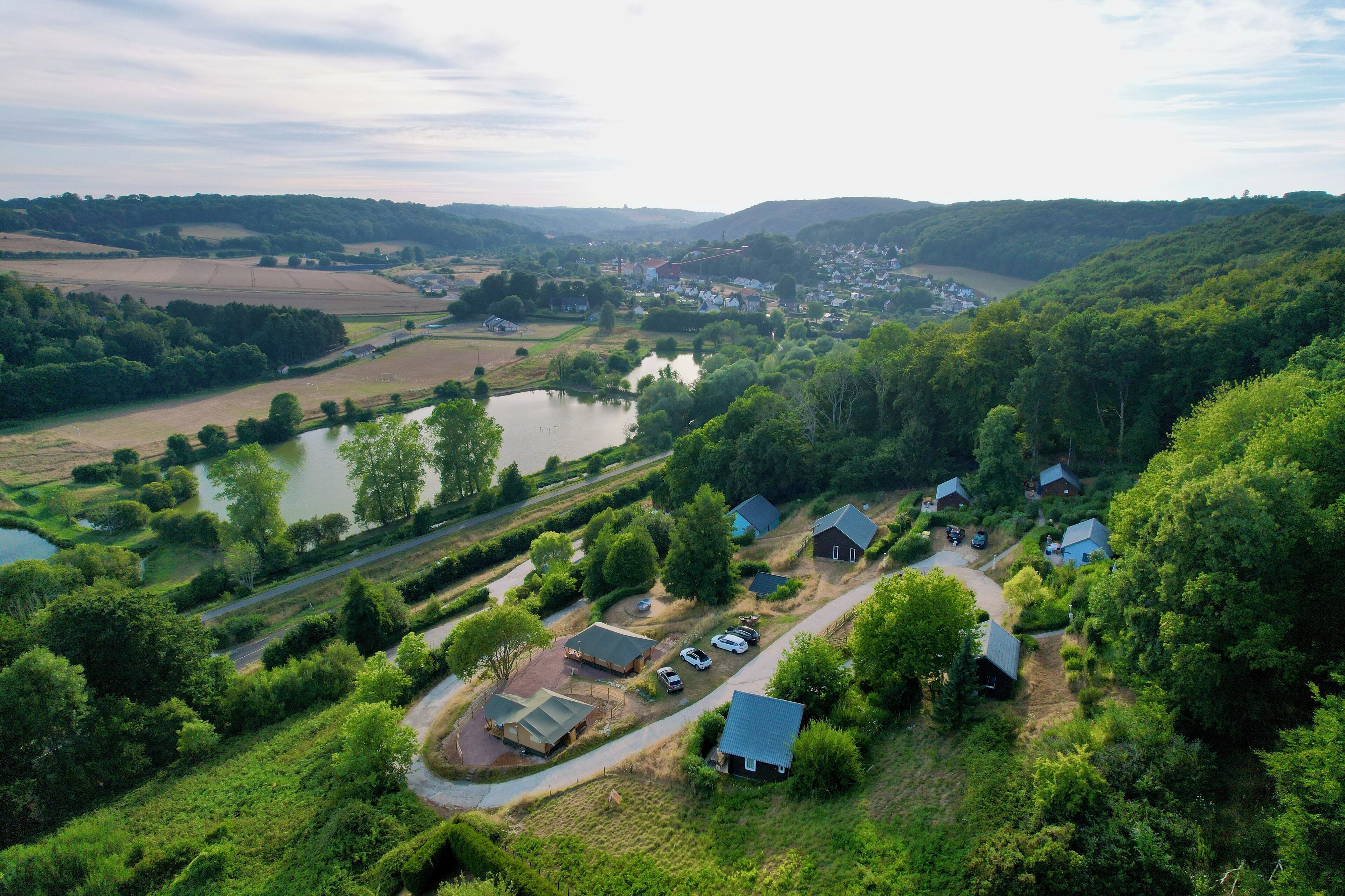 Vista aérea de una zona rural con casas, un lago y vegetación circundante.