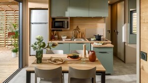 A modern kitchen with a central island, built-in appliances, and a dining area with a table and chairs.