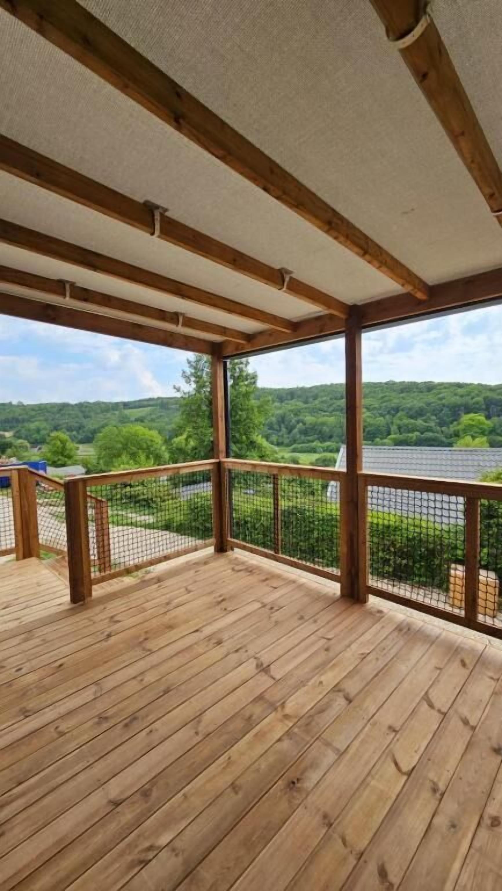 Una terraza de madera con vista a un lago y un bosque.