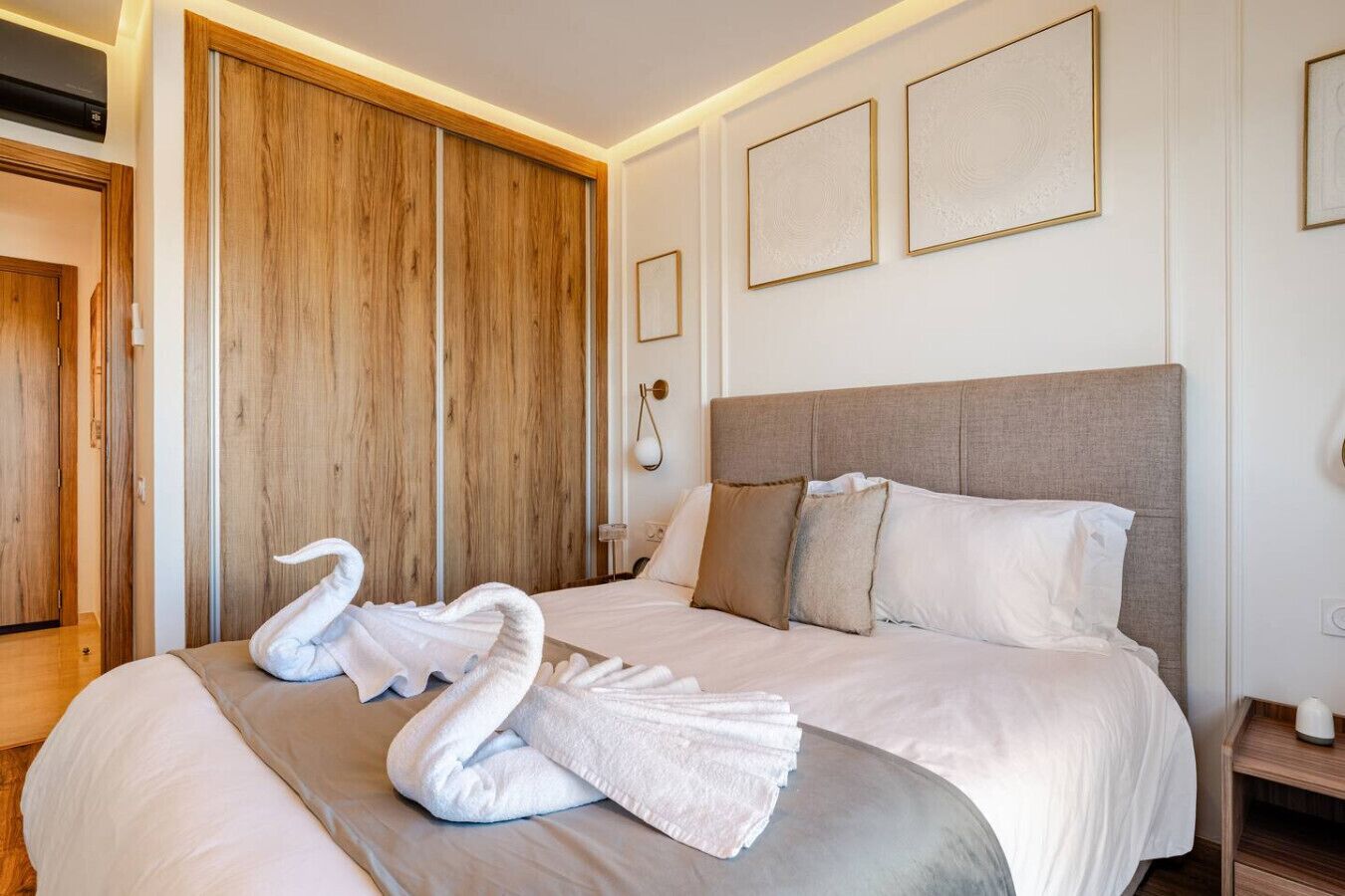 Ein Hotelzimmer mit einem großen Bett, einem Holzschrank und einem gerahmten Kunstwerk an der Wand.