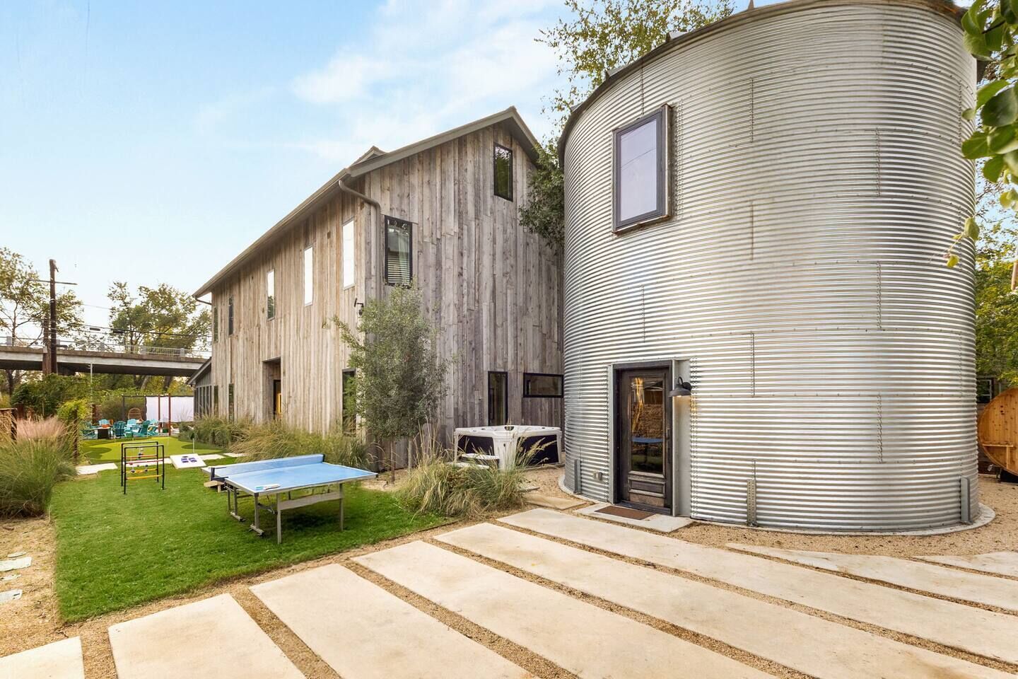 A modern building with a wooden exterior and a cylindrical metal structure.