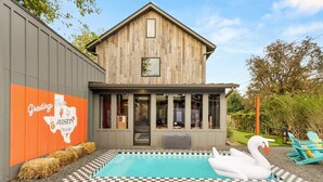 Un bâtiment de style rustique doté d’une piscine et agrémenté d’une décoration représentant des cygnes.
