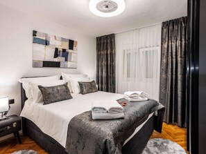 A modern hotel room with a large bed, a bedside table, a wall art piece, and a window with curtains. - Serene Family Villa by the Rogoznica Coast (Rogoznica)