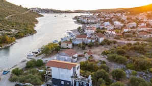 A coastal town with a marina, houses, and a large building with a pool. - Serene Family Villa by the Rogoznica Coast (Rogoznica)