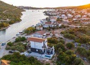 A coastal town with a marina, houses, and a large building with a pool. - Serene Family Villa by the Rogoznica Coast (Rogoznica)