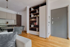 Ein modernes Wohnzimmer mit einer Couch, einem Esstisch und einem Bücherregal.