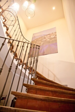 A spiral staircase with wooden steps and metal railings, leading to a landing with a wall-mounted picture. - Charming Provencal farmhouse with swimming pool and jacuzzi  sleeps up to 8 🌿☀️ (Loriol-du-Comtat)