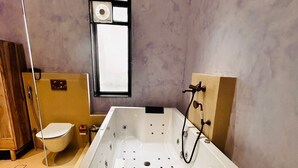 A bathroom with a bathtub, toilet, and a mirror. - SADRI HAVELI Boutique Heritage Hotel - Lake Pichola Udaipur (Udaipur)