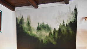 A bed with a green blanket, pillows, and a wall painting of a forest. - Gio's house, apartment with garden and barbecue, relaxation in the midst of nature (ville sur sarre)