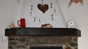 A stone fireplace with a mantel, a red cup, and decorative items. - Gio's house, apartment with garden and barbecue, relaxation in the midst of nature (ville sur sarre)