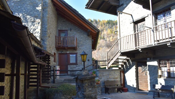 A stone building with a wooden balcony, a stone well, and a bench. - Gio's house, apartment with garden and barbecue, relaxation in the midst of nature (ville sur sarre)