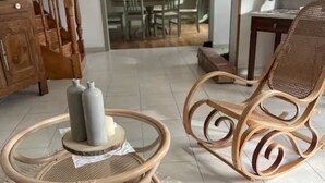 Un salon avec un escalier en bois, un coin repas et une cuisine.