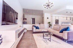 A modern living room with a sofa, coffee table, and a TV mounted on the wall. - Luxury Villa Retreat in Sestanovac (Sestanovac)