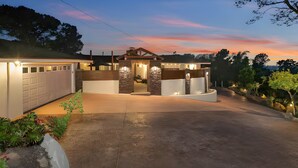 A modern house with a garage, a covered patio, and a landscaped driveway. - Sunset Summit by Coastline Vacation Rentals (La Mesa)