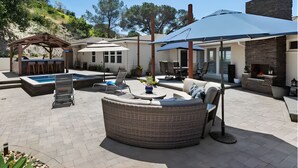 A backyard with a pool, outdoor seating, and a barbecue area. - Sunset Summit by Coastline Vacation Rentals (La Mesa)