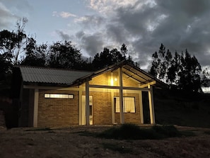 Un edificio de una planta con techo inclinado, fachada de ladrillo y un pequeño porche.