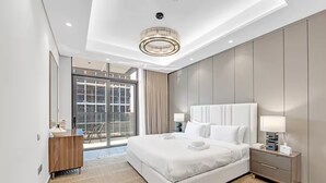 Een moderne hotelkamer met een groot bed, een nachtkastje, een bureau en uitzicht op de omgeving.
