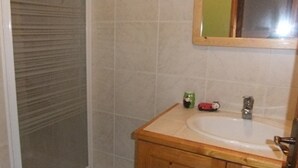 Une salle de bain avec un meuble-lavabo en bois, un évier et un miroir.