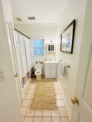 Une salle de bain avec des toilettes, un lavabo et un miroir.