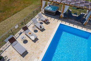 A rooftop pool area with lounge chairs, a hot tub, and a pergola. - Stylish Villa in Lovrec With Sauna for 10 (Lovreć)