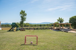 A grassy outdoor area with a playground, a soccer goal, and a pergola. - Stylish Villa in Lovrec With Sauna for 10 (Lovreć)