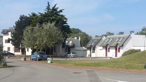 A residential area with houses, a road, and parked cars. - 33m2 apartment in the heart of the dunes, 5 minutes from the beach (Le Touquet)