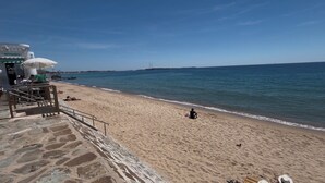 A beach with a stone wall, a restaurant named 'ROMÉO' with outdoor seating, and a clear view of the sea. - Cannes SeaView: Infinity Pool, Tennis, 2 Terraces, Bathtub & 10m to Palais + AC (Cannes)
