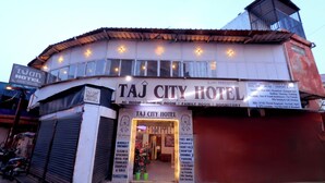 A Taj City Hotel with a signboard listing amenities like AC rooms, a rooftop dining area, and free WiFi. - TAJ CITY HOTEL  (Agra)
