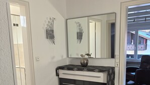 A modern kitchen with a black and white countertop, a stainless steel oven, and a large mirror above the sink.