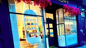 Un escaparate con un letrero que dice 'Nail Luxury London' y un escaparate que exhibe diversos productos.