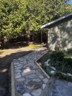 A stone pathway leading to a house with a mailbox marked '9262B' and a mailbox box filled with mail.