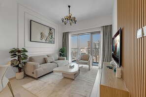 Ein modernes Wohnzimmer mit einer Couch, einem Sessel, einem Couchtisch und einem großen Fernseher.