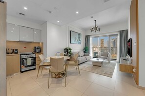 Ein modernes Wohnzimmer mit Küche, Essbereich und großem Fenster mit Blick auf die Stadt.