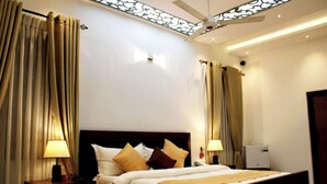 A hotel room with a bed, two bedside tables with lamps, a ceiling fan, and curtains. - Hotel Sky Gate Kandy  (Kandy)