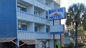 En bygning med flere etager, med skilt, der siger "Beach Side Hotel".