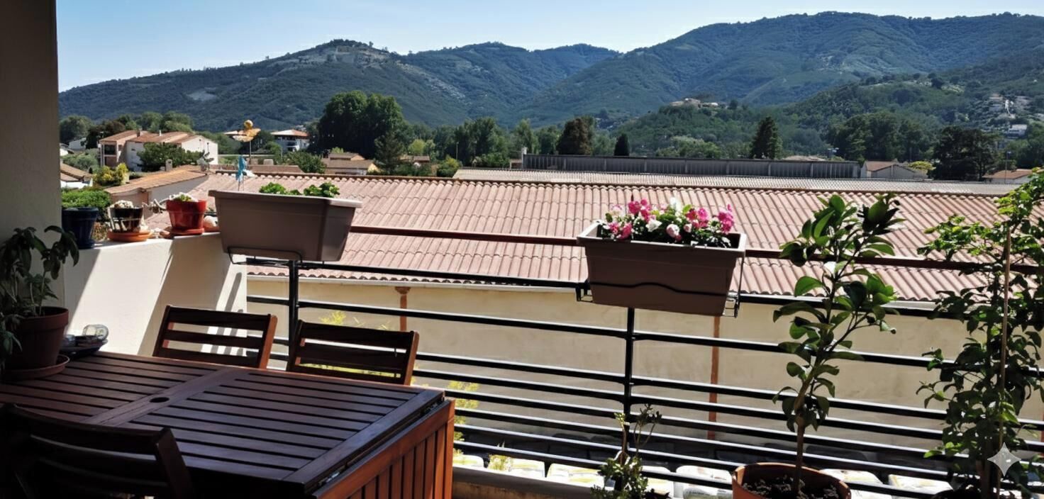 Un balcone con un tavolo e sedie in legno, piante in vaso e fioriere.
