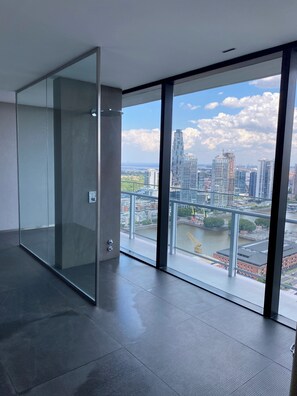 A modern office space with a large glass wall offering a city view. - Charming studio on the 33rd floor in the best location in Buenos Aires (Buenos Aires)