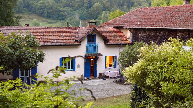 A traditional house with a blue door and windows, surrounded by greenery. - Charming Old Farmhouse in Secluded Nature – Perfect for Family & Friends (Sédeilhac)